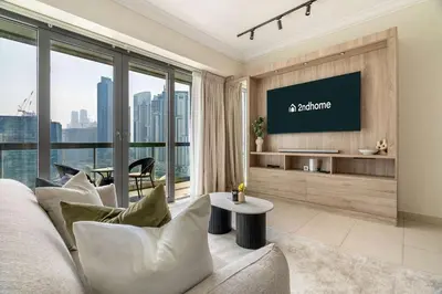 a living room with a couch and a tv at Stylish Living at 8 Boulevard Walk, Downtown in Dubai