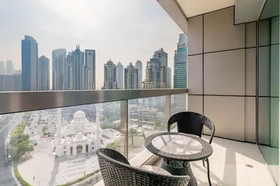 a balcony with a table and chairs and a view of a city at Stylish Living at 8 Boulevard Walk, Downtown in Dubai