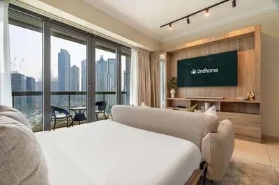 a hotel room with a bed and a flat screen tv at Stylish Living at 8 Boulevard Walk, Downtown in Dubai