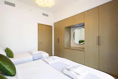 two beds in a room with a mirror at 1BR in Emaar Burj Royale - 1min walk to Fountain&Dubai Mall, Burj view Pool & gym in Dubai