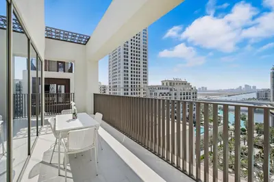 a balcony with a table and chairs and a view of the city at New 3BD in Grove Creek Beach with Stunning View in Dubai