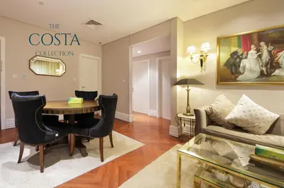 a living room with a table and a couch at Water Edge 2BR - Panoramic 360 Canal View in Dubai