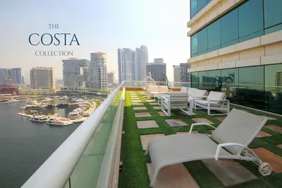 a balcony with chairs and a view of a city at Water Edge 2BR - Panoramic 360 Canal View in Dubai