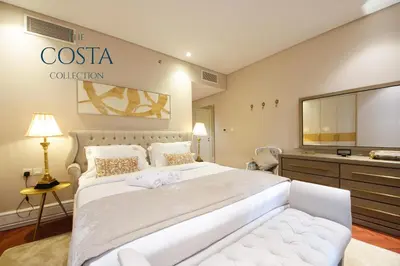 a hotel room with a large bed and a television at Water Edge 2BR - Panoramic 360 Canal View in Dubai