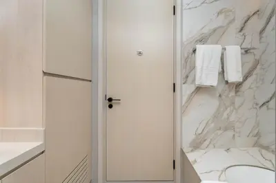a white bathroom with a marble wall at 1BR w Marina Views & Balcony in Dubai
