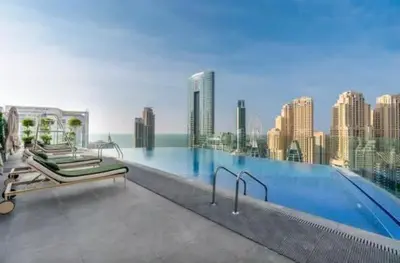 a swimming pool with two beds on top of a building at 1BR w Marina Views & Balcony in Dubai