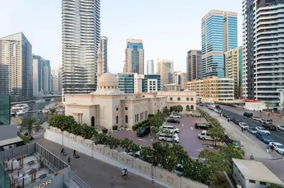 a building in the middle of a city with tall buildings at 1BR w Marina Views & Balcony in Dubai