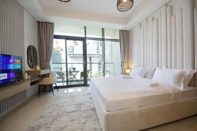 a bedroom with a large white bed and a television at Luxury Studio in Aykon Tower - Pool & Gym Access in Dubai