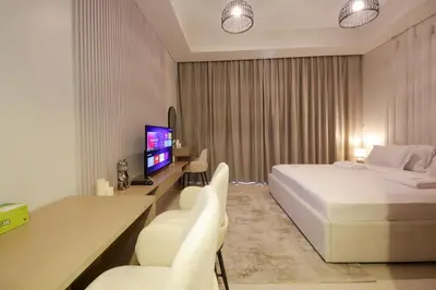 a hotel room with a bed and a desk and chairs at Luxury Studio in Aykon Tower - Pool & Gym Access in Dubai