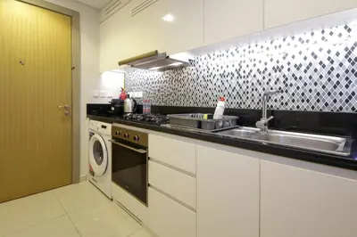 a kitchen with a sink and a washing machine at Luxury Studio in Aykon Tower - Pool & Gym Access in Dubai