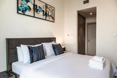 a bedroom with a large bed with white sheets and pillows at Exotic 2 bed downtown Burj Khalifa dist Dubai mall in Dubai