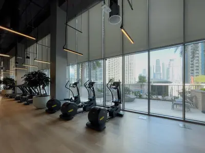 a gym with treadmills and ellipticals in a room with windows at Exotic 2 bed downtown Burj Khalifa dist Dubai mall in Dubai