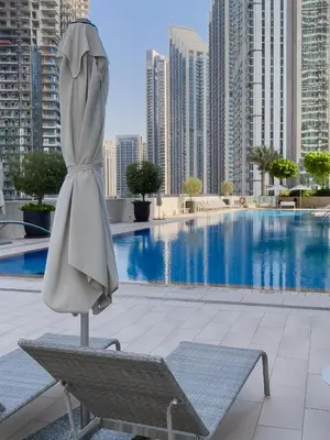 a umbrella and a chair next to a swimming pool at Exotic 2 bed downtown Burj Khalifa dist Dubai mall in Dubai