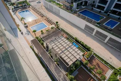 an overhead view of a building with two swimming pools at Escape24 Stylish 2BR with Pool View at Azizi Riviera in Dubai