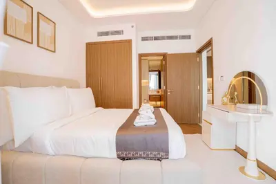 a white bedroom with a bed and a sink at Escape24 Stylish 2BR with Pool View at Azizi Riviera in Dubai