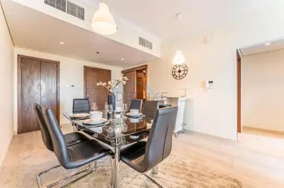 a dining room with a glass table and black chairs at 1BR Near Burj Khalifa and Dubai Mall, Easy Access to Dubai Marina and Palm Jumeirah by Road or Metro, BLVD Walk, Downtown Dubai by Deluxe Holiday Homes in Dubai