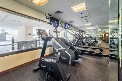 a gym with two treadmills and a treadmill at 1BR Near Burj Khalifa and Dubai Mall, Easy Access to Dubai Marina and Palm Jumeirah by Road or Metro, BLVD Walk, Downtown Dubai by Deluxe Holiday Homes in Dubai