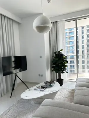 a white living room with a couch and a tv at OceanView 1bed apartment with Private Beach in Dubai