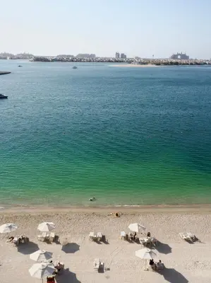 a beach with chairs and umbrellas and the ocean at OceanView 1bed apartment with Private Beach in Dubai