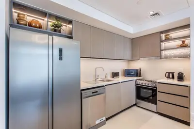a kitchen with a refrigerator and a sink at Downtown Luxury 2 Bed Apartment in Dubai