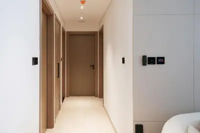 a hallway with white walls and a door at JVC - Designer 2 BHK apartment - Pool&Gym - by MKB LIVING in Dubai