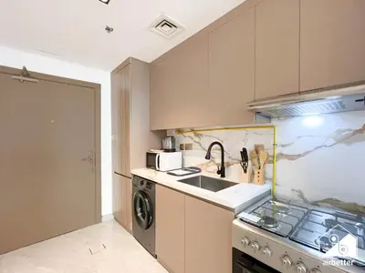 a kitchen with a sink and a stove at Relaxing ST Getaway l Balcony, Pool & Gym Access in Dubai