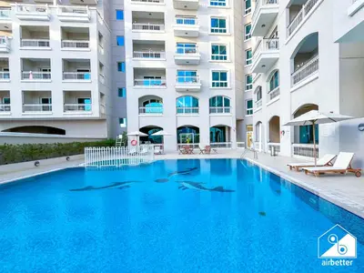 a swimming pool in front of a building at Relaxing ST Getaway l Balcony, Pool & Gym Access in Dubai