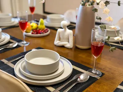 a table with a bowl and plates and wine glasses at Jumeirah Beachfront with Ain View and Sea View 2BR in Dubai