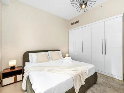 a bedroom with a large bed with white cabinets at Jumeirah Beachfront with Ain View and Sea View 2BR in Dubai