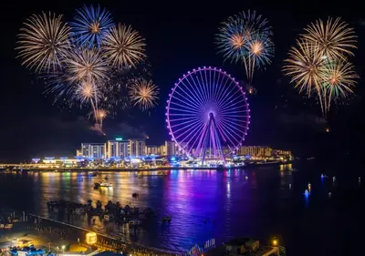 a ferris wheel with fireworks over a city at night at Jumeirah Beachfront with Ain View and Sea View 2BR in Dubai