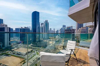 a balcony with two chairs and a view of a city at Modern Sophistication with Stunning City Views in Dubai
