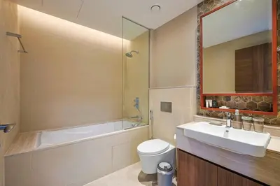 a bathroom with a sink and a tub and a toilet at Modern Sophistication with Stunning City Views in Dubai