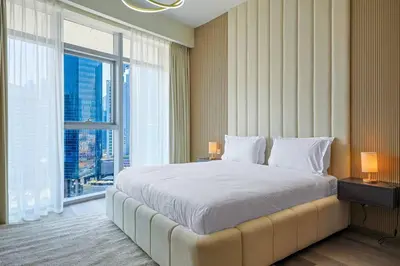 a bedroom with a large bed and a large window at Modern Sophistication with Stunning City Views in Dubai