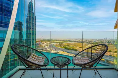 two chairs on a balcony with a view of a city at Luxury Studio Retreat Canal View and City Life in Dubai