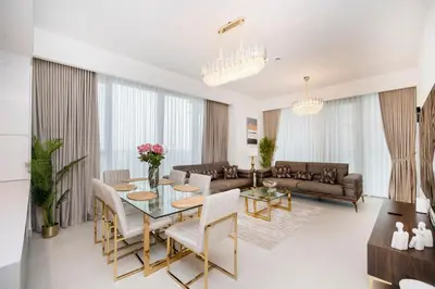 a living room with a table and chairs at Cozy 2BR APT With Canal Views, Pool with Burj View in Dubai