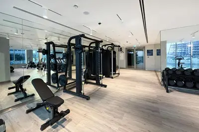 a gym with a row of treadmills and weights at Cozy 2BR APT With Canal Views, Pool with Burj View in Dubai