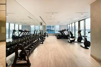 a gym with rows of treadmills and elliptical machines at Cozy 2BR APT With Canal Views, Pool with Burj View in Dubai