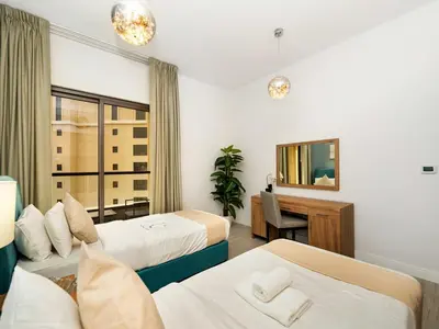 a hotel room with two beds and a desk at JBR Beachfront with Full Sea and Ain Dubai View in Dubai