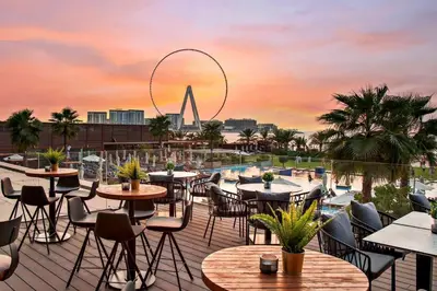 a rooftop patio with tables and chairs with a view of the olympics at JBR Dubai VIP Lux Penthouse priv Pool cinema Limo tranfer-housekeeper in Dubai