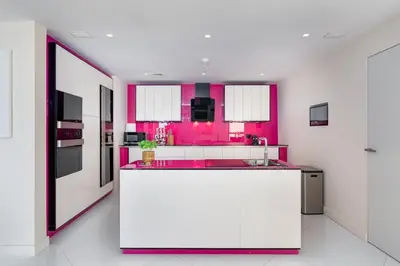a kitchen with pink walls and a large white island at JBR Dubai VIP Lux Penthouse priv Pool cinema Limo tranfer-housekeeper in Dubai