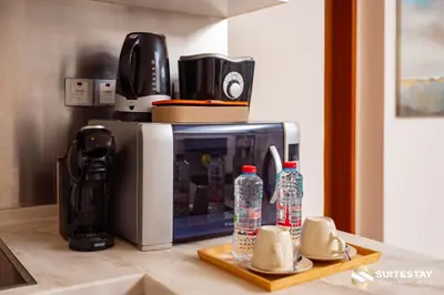 a microwave sitting on a counter with bottles of water at Suitestay-Fahion Avenue Dubai mall in Dubai