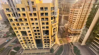 an aerial view of a tall yellow apartment building at Private Double Room In Barsha Heights Near Metro in Dubai