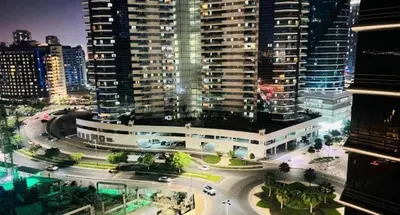 a view of a building in a city at night at The Cozy Classic Room In Barsha Heights ICM Metro in Dubai