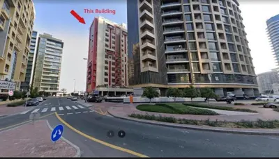 a city street with a large building in the background at The White Haven Room in Tecom Barsha Heights in Dubai