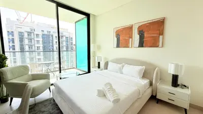 a bedroom with a bed and a chair and a window at Premium Studio In Jvc Bazr in Dubai