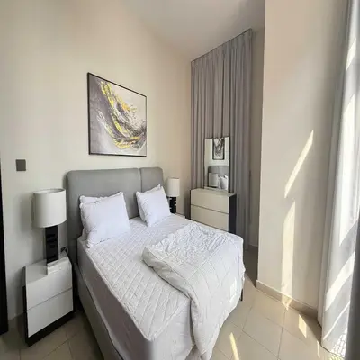 a bedroom with a bed with white sheets and pillows at Premium Studio In Jvc Bazr in Dubai