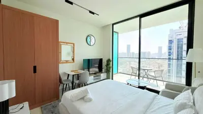 a bedroom with a bed and a large window at Premium Studio In Jvc Bazr in Dubai