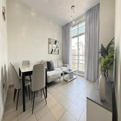 a living room with a table and a couch at Premium Studio In Jvc Bazr in Dubai