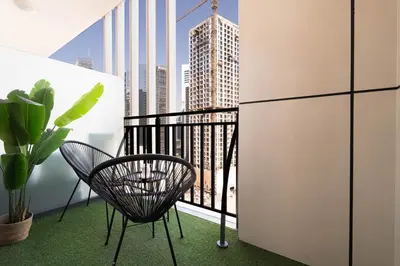 a chair on a balcony with a view of a city at Stylish 1-Bedroom with Lake View in Business Bay in Dubai