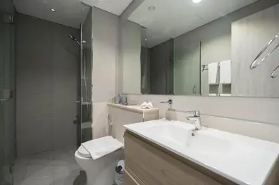 a bathroom with a sink and a toilet and a mirror at Stylish 1-Bedroom with Lake View in Business Bay in Dubai